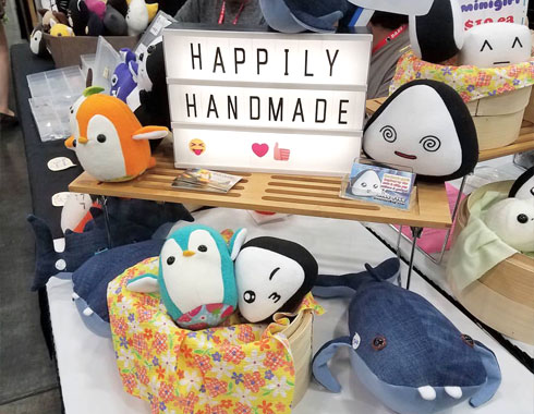 happily handmade sign with plush onigiri and penguins